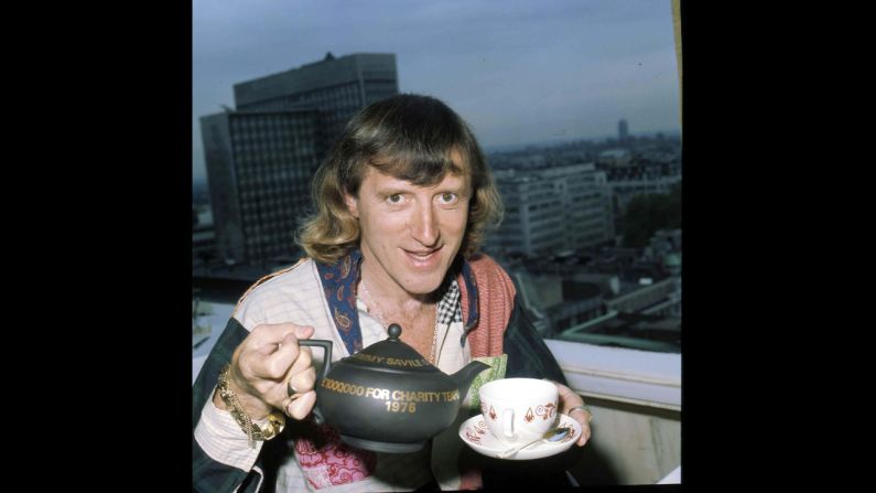 Savile pours a cup of tea.