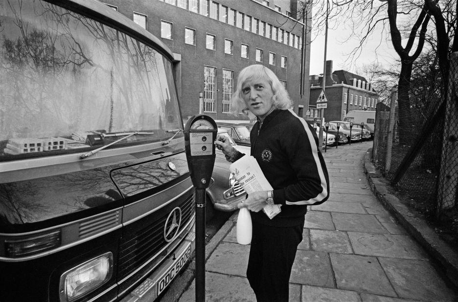 Savile stands on the sidewalk with his motor home.