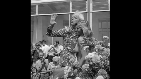 Savile waves with Jersey Holiday Queen Gaynor Lacey at the Jersey Battle of Flowers carnival in 1972.