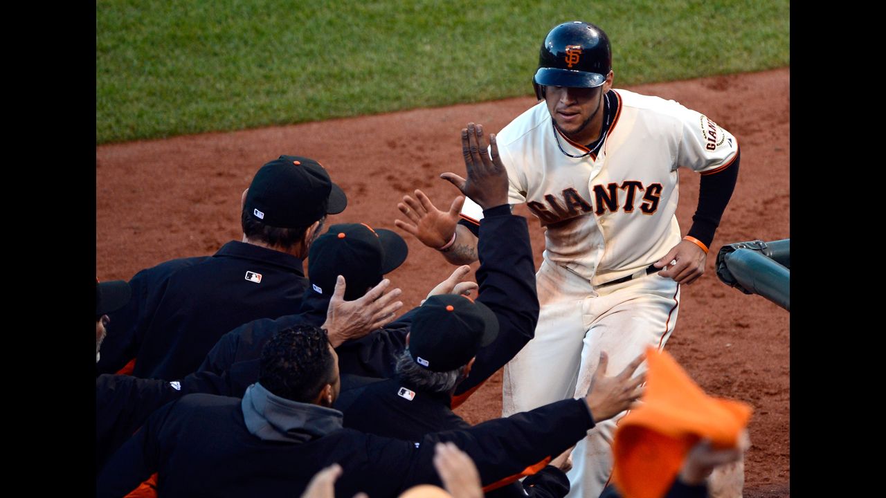 No. 7 Gregor Blanco of the Giants is congratulated by manager Bruce Bochy after Blanco scores on a base hit by No. 18 Matt Cain in the second inning.