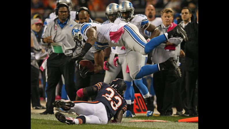 No. 87 Brandon Pettigrew of the Lions is hit and flipped out of bounds by No. 33 Charles Tillman of the Bears.
