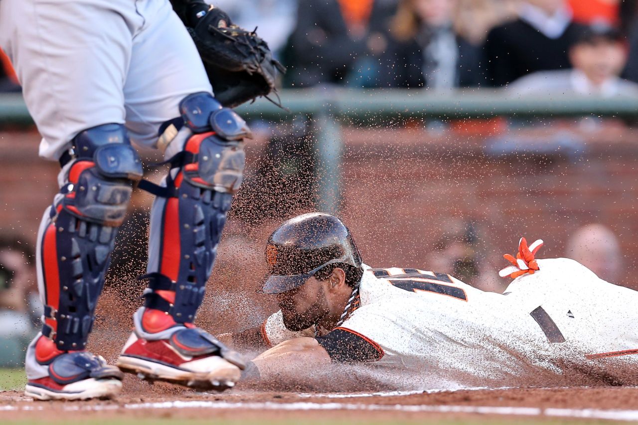 No. 16 Angel Pagan of the Giants slides home to score in the first inning on an infield groundout by No. 48 Pablo Sandoval against the Cardinals.