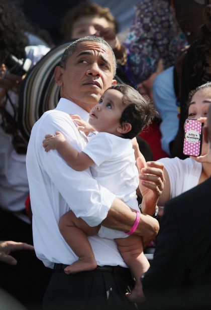 President Obama holds a baby as he greets people during a campaign rally at the Delray Beach Tennis Center on Tuesday, October 23, in Delray Beach, Florida. Obama continues to campaign across the United States in the run-up to the November 6 presidential election.