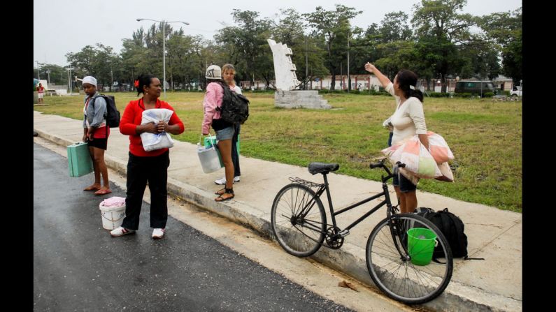 Citizens of Bayamo talk on the sidewalk on Wednesday.