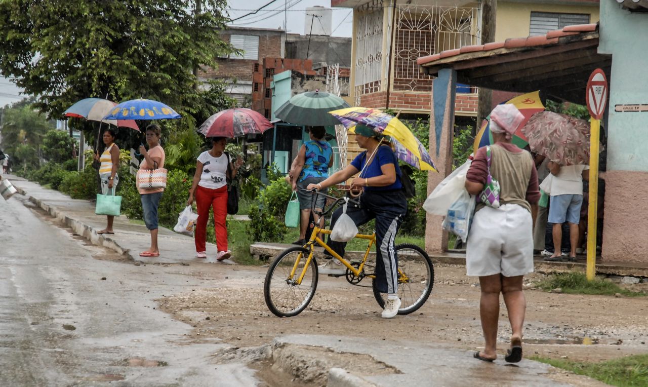 People in Bayamo hold umbrellas as they purchase food Wednesday before the arrival of the hurricane.
