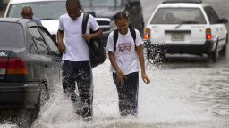 Dominican school children walk in the flooded streets of Santo Domingo before the arrival of Hurricane Sandy on Thursday, October 24, 2012. 