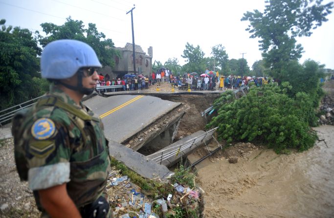 A U.N. peacekeeper on Thursday stands at the edge of a bridge that was washed away by heavy rains from Hurricane Sandy in Port-au-Prince, Haiti.