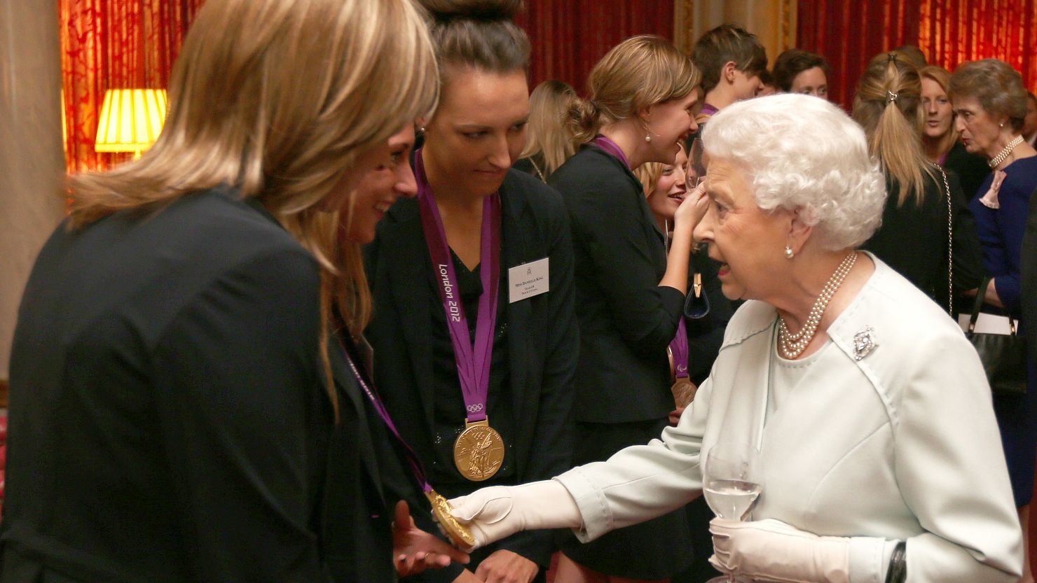 The queen meets British Olympians at a reception hours before two athletes had their medals stolen from a London nightclub.