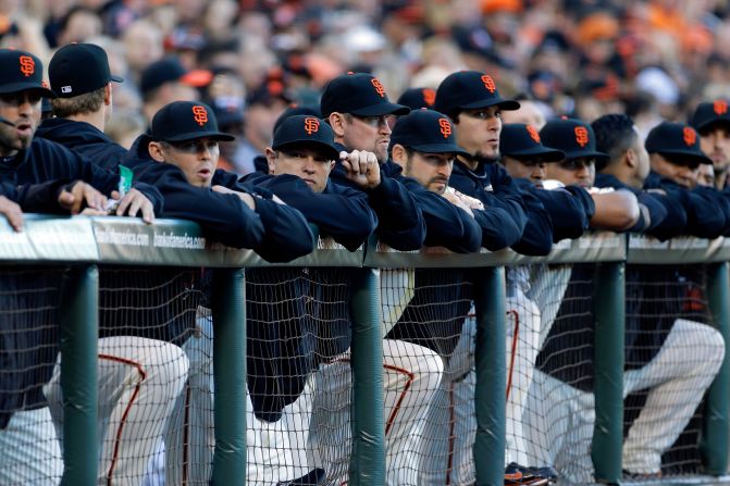 San Francisco Giants players look on from the dugout.