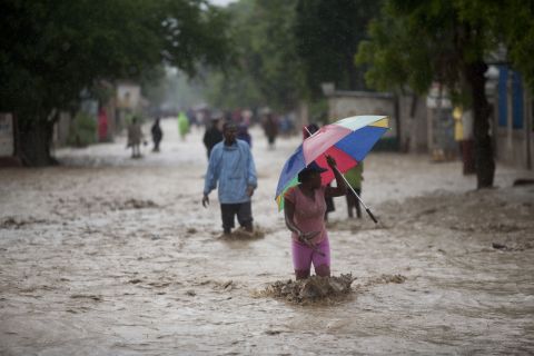 People walk on a flooded street after Hurricane Sandy hit Port-au-Prince, Haiti, on Thursday.