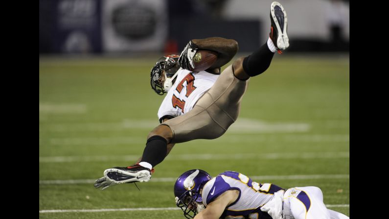 Arrelious Benn of the Tampa Bay Buccaneers flies into the air after a tackle by Harrison Smith of the Minnesota Vikings during the fourth quarter of the game on Thursday, October 25, at Mall of America Field at the Hubert H. Humphrey Metrodome in Minneapolis. The Buccaneers defeated the Vikings 36-17.