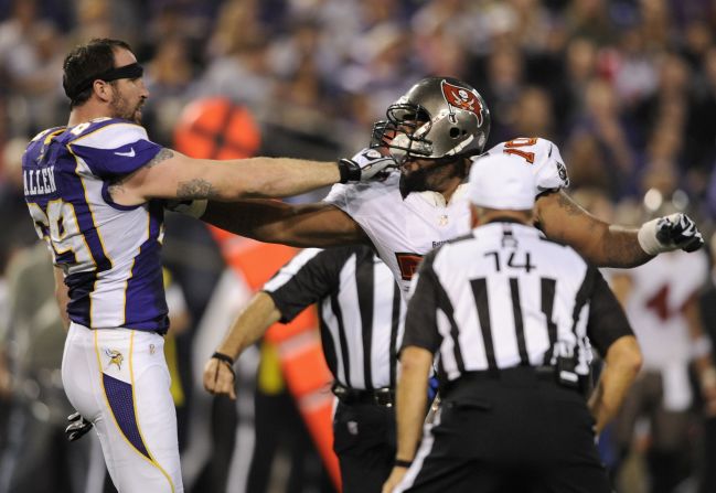 Jared Allen of the Vikings holds the mask of Donald Penn of the Buccaneers as referee Ron Winter looks on during the third quarter.