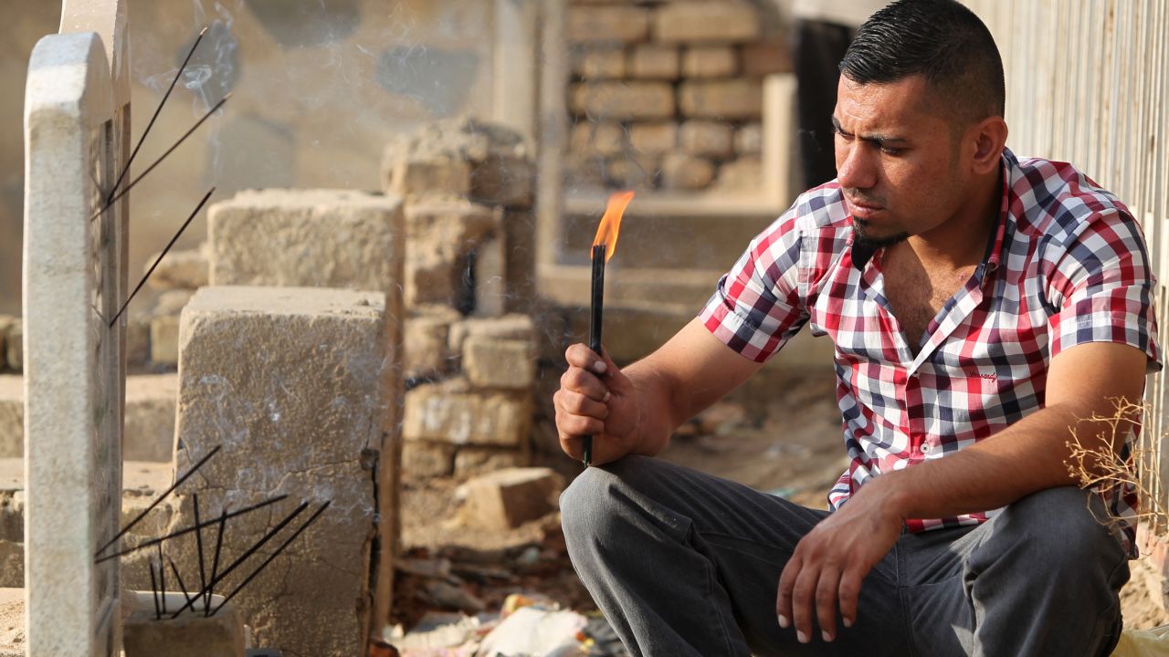 An Iraqi man prays next to a grave in Baghdad on the first day of Eid al-Adha on October 26.