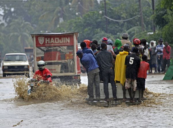 A motorcyclist rides through a flooded street Friday in Petit-Goâve, Haiti, where three overflowing rivers put homes and farms under water.