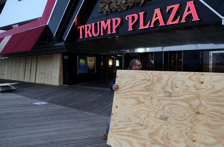 Scott Davenport brings plywood to cover the windows at the Trump Plaza casino on the boardwalk in Atlantic City, New Jersey, on Sunday. 