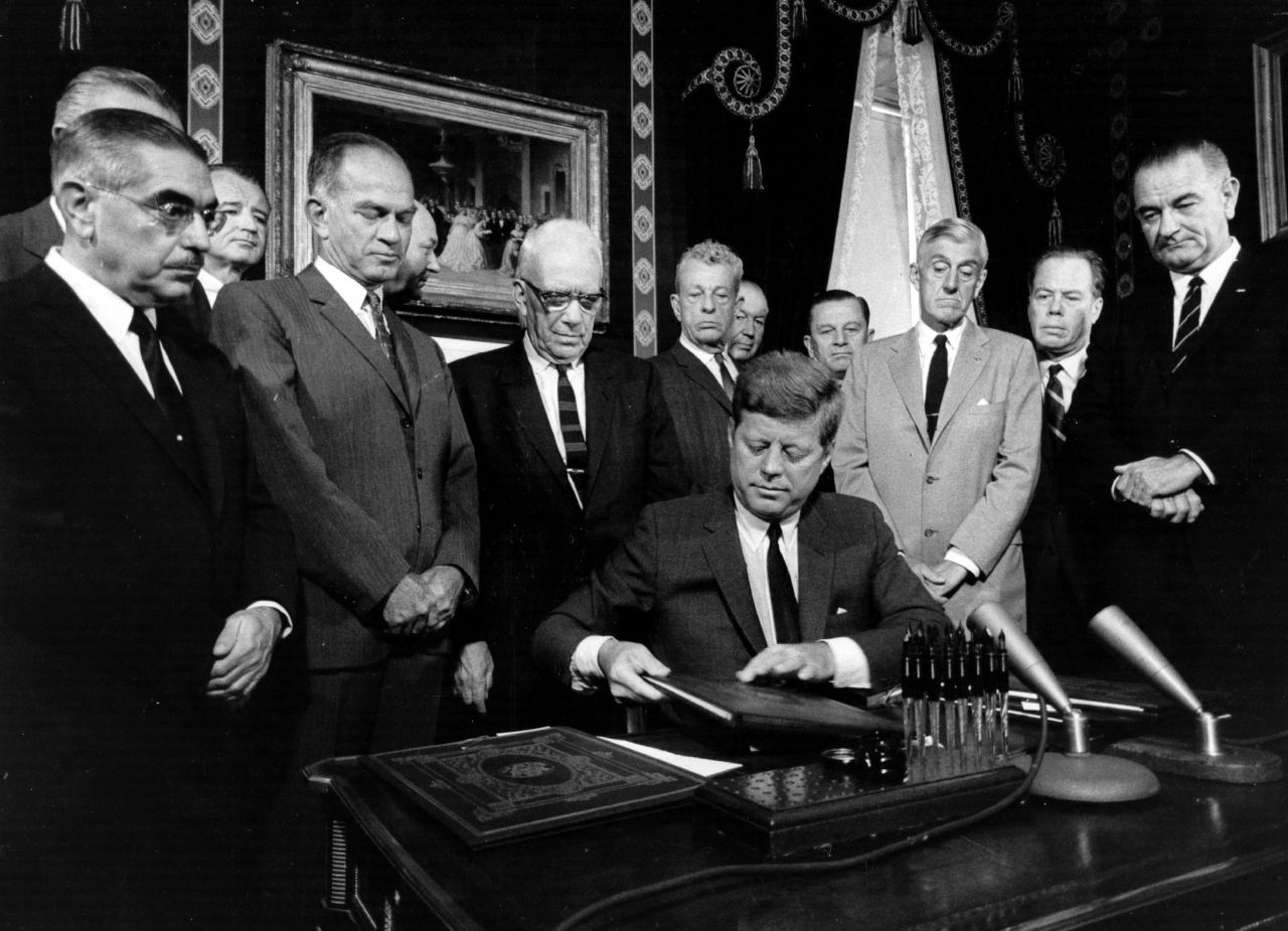 John F. Kennedy signs the nuclear test ban treaty before senators, Vice President Lyndon B. Johnson, right, and Secretary of State Dean Rusk, second from left, foreground. Take a look at what other presidents have done to secure their legacy.