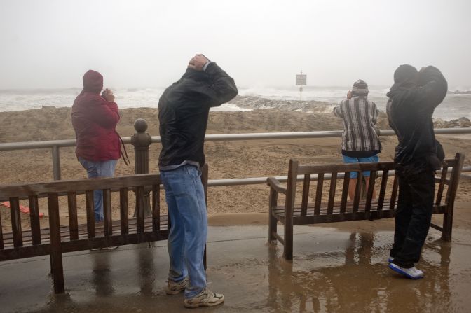 People look at the surf as high winds and heavy rain from Hurricane Sandy arrive in Virginia Beach, Virginia, on Sunday.