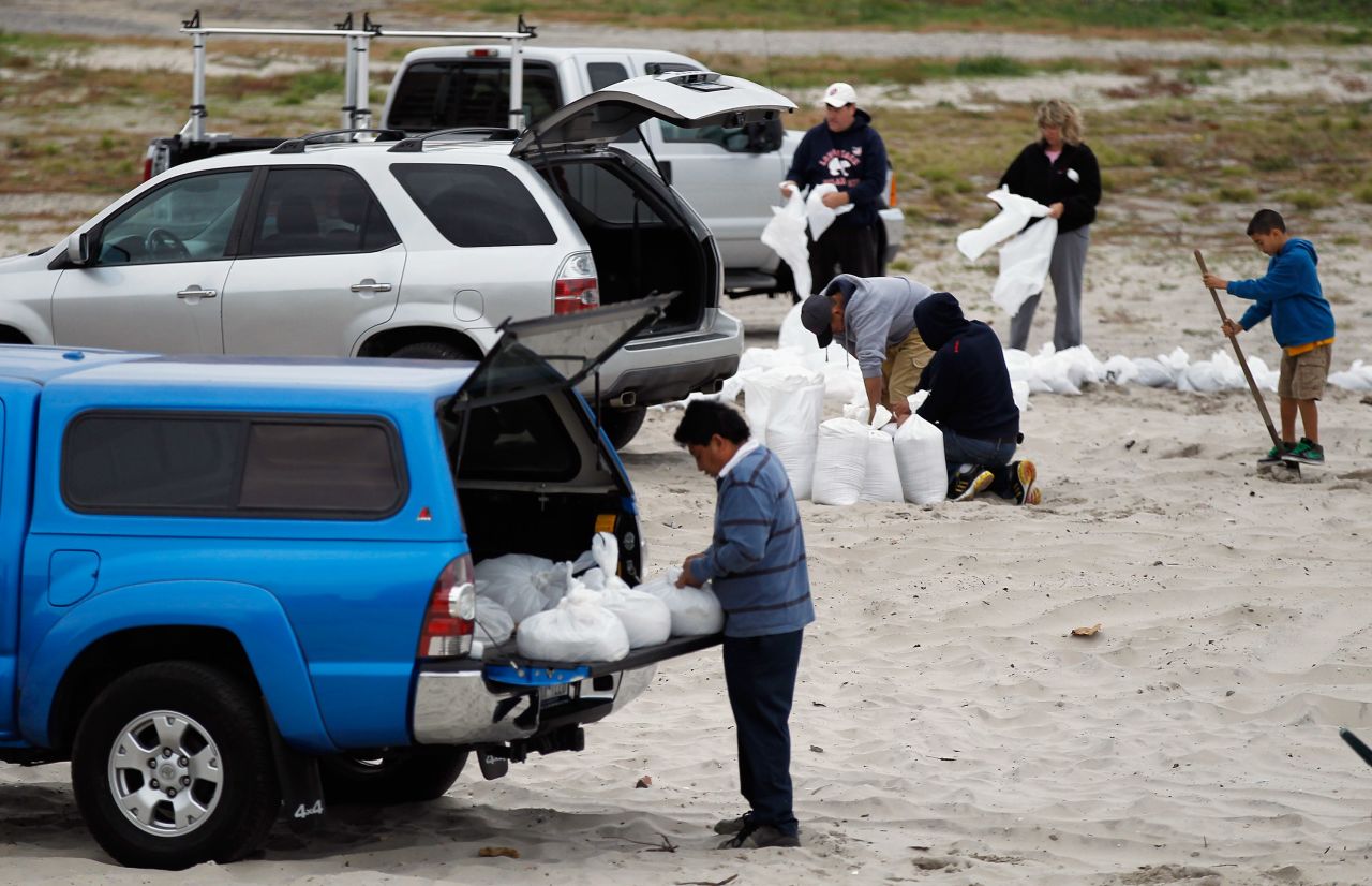 Residents of Long Beach, New York, fill sandbags on Sunday in preparation for the storm.