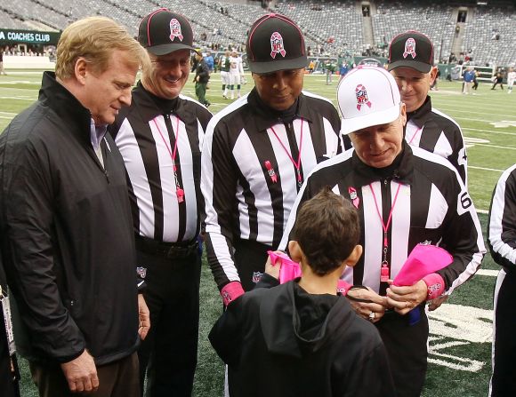 Dante Cano, 11, presents referee Walt Anderson with a pink penalty flag supporting breast cancer awareness, as Commissioner Roger Goodell, left, looks on, prior to a game between the New York Jets and the Miami Dolphins at MetLife Stadium on Sunday in East Rutherford, New Jersey.