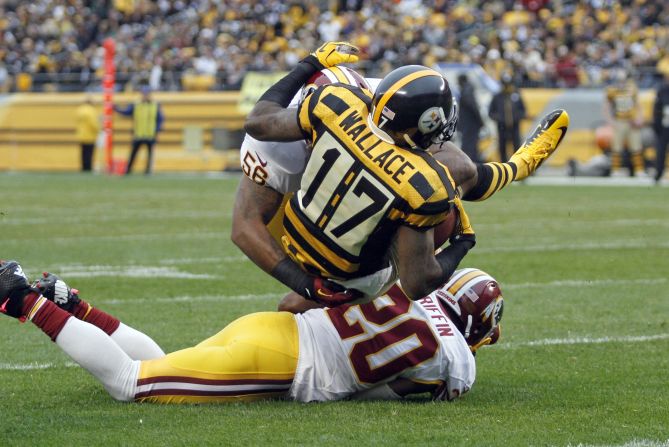 Mike Wallace of the Pittsburgh Steelers is tackled by No. 20 Cedric Griffin and No. 56 Perry Riley of the Washington Redskins during Sunday's game in Pittsburgh.