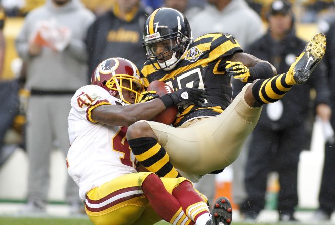 Mike Wallace of the Steelers makes a catch on Sunday and is hit by Madieu Williams of the Redskins.