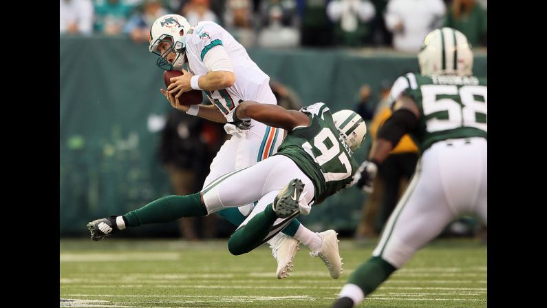 Quarterback Ryan Tannehill of the Miami Dolphins is sacked by outside linebacker Calvin Pace of the New York Jets at MetLife Stadium on Sunday in East Rutherford, New Jersey.