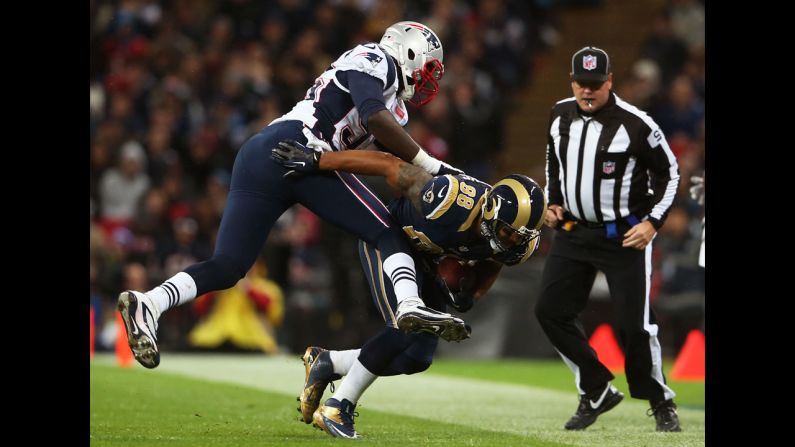 Lance Kendricks of the Rams is pushed out of bounds by Chandler Jones of the Patriots on Sunday.