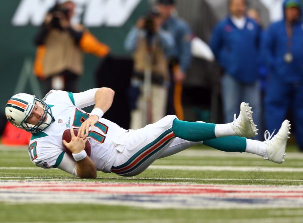 Miami's Ryan Tannehill of the Miami Dolphins falls after he is sacked by New York's Calvin Pace on Sunday.