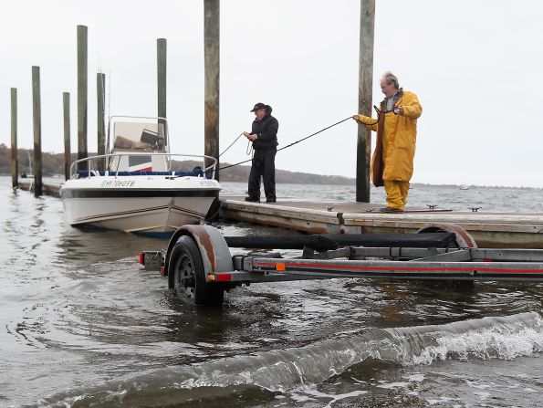 Sean Doyle of Levittown and Andrew Hodgson of Hicksville pull their boat from Long Island Sound on Sunday at Oyster Bay, New York.