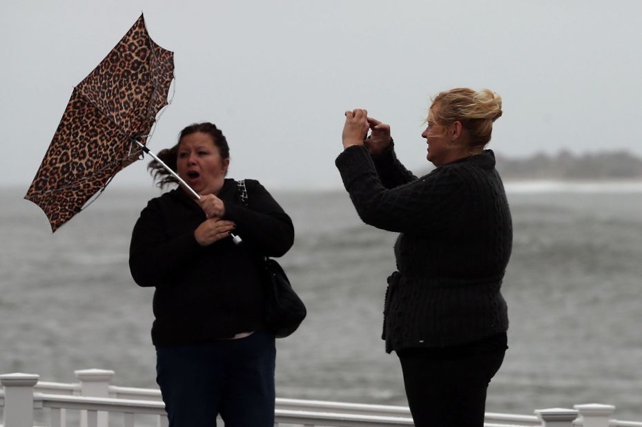 Lisa Cellucci holds her umbrella as it is blown backward by Hurricane Sandy's winds as her friend Kim Vo watches on Sunday in Cape May.