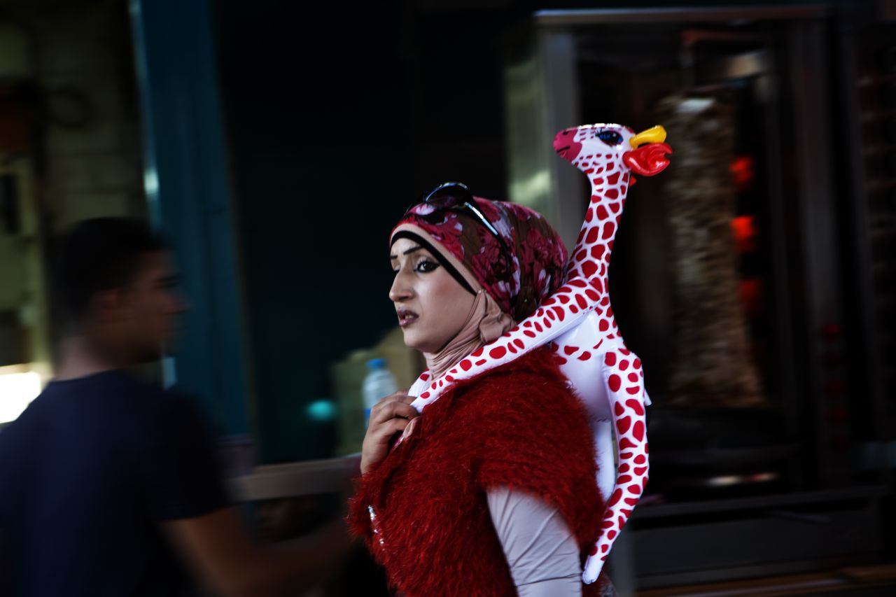 An Arab Israeli woman walks with an inflatable giraffe on her back during a festival on the second day of Eid al-Adha Sturday in Acre.