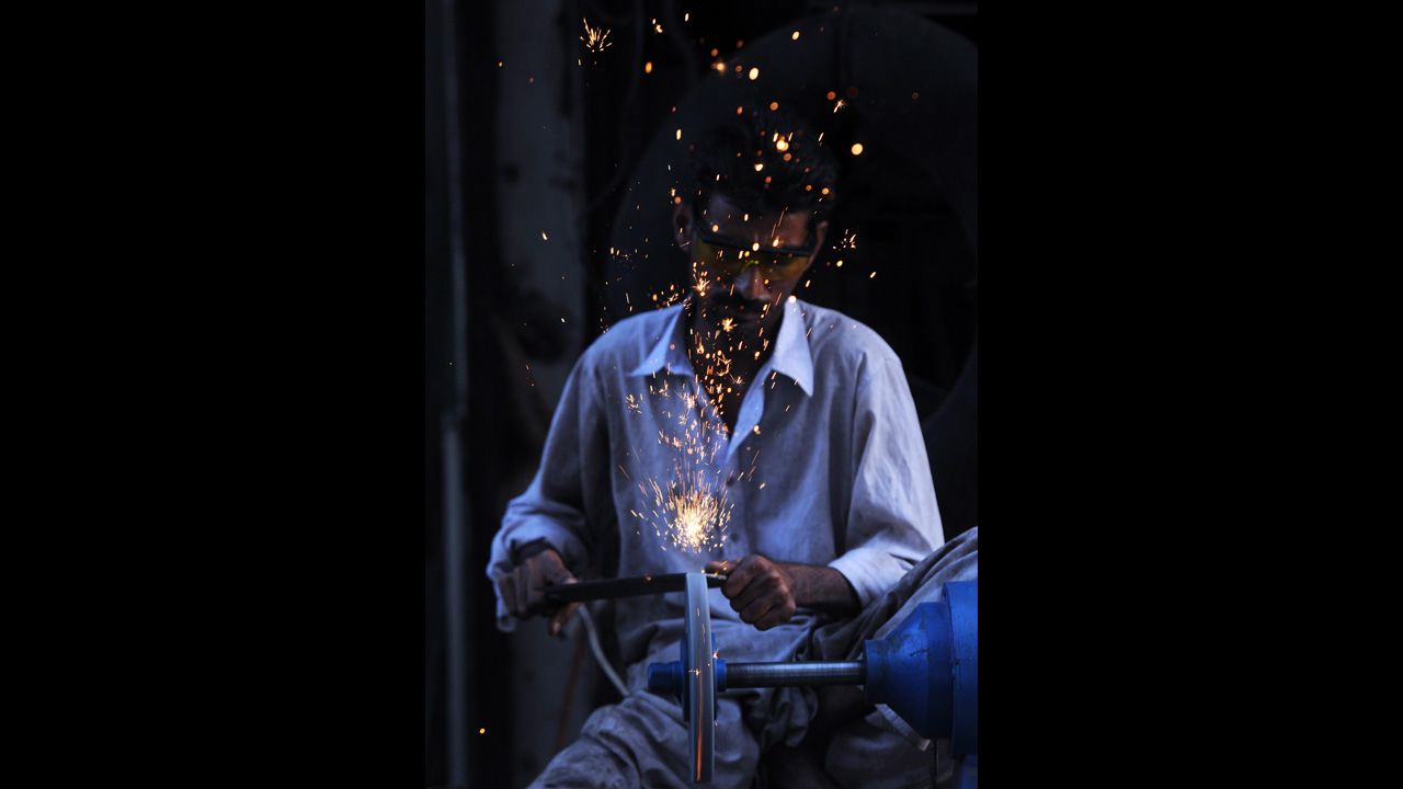 A Pakistani vendor sharpens knives at a stall ahead of the Muslim sacrificial festival in Karachi, Pakistan, on Thursday, October 25.