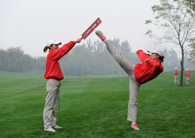 A course marshall practices kung fu as she awaits the golfers' arrival. 