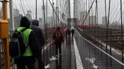 People walk across a rainy Brooklyn Bridge as New York City braces for Hurricane Sandy's arrival.