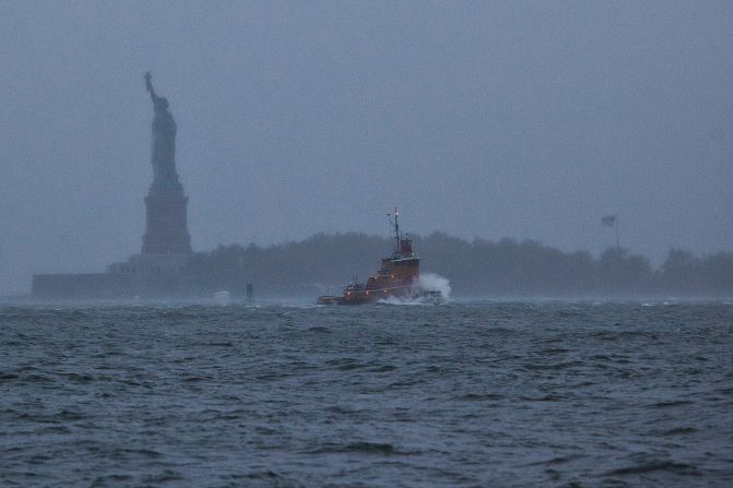 A wave crashes over the bow of a tugboat in New York Harbor on Monday.