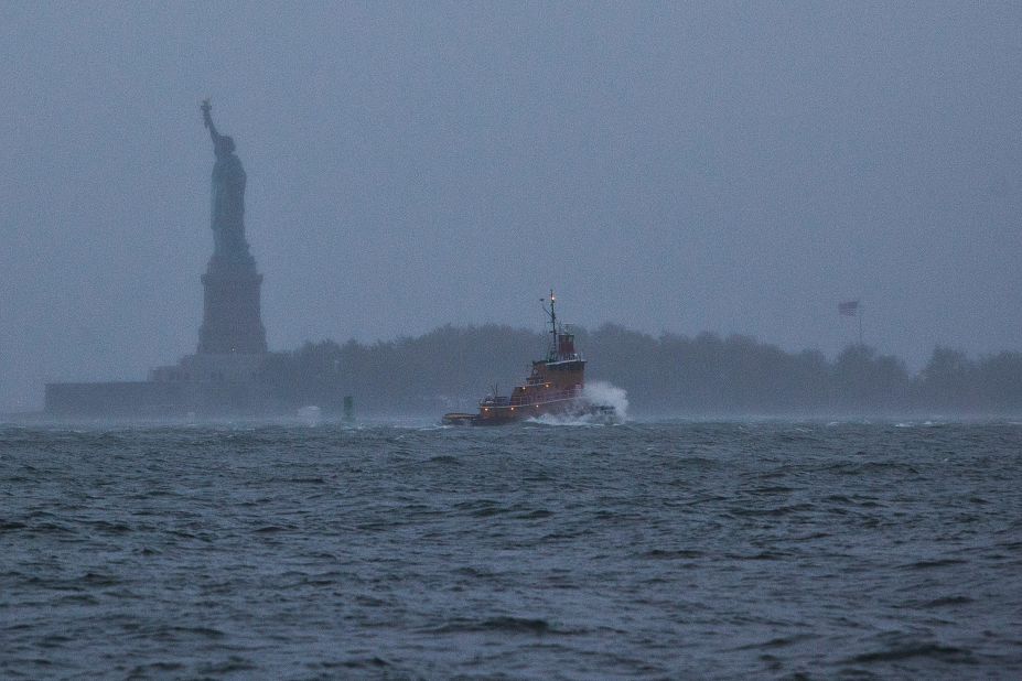  A wave crashes over the bow of a tugboat in New York Harbor on Monday.