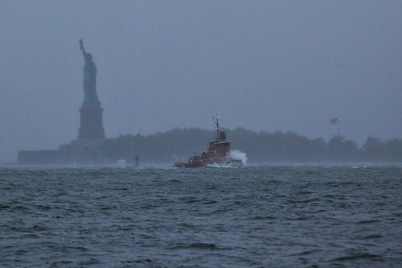  A wave crashes over the bow of a tugboat in New York Harbor on Monday.