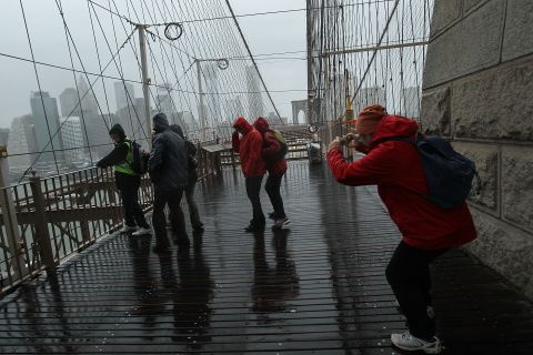 People pose for pictures on the Brooklyn Bridge on Monday.