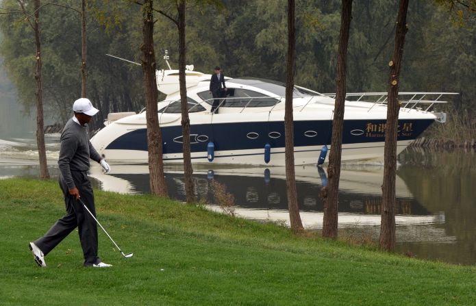 Woods tries to maintain focus as a luxury boat passes by, with the clubhouse car park also boasting a collection of Rolls-Royces, Ferraris,  Aston Martins and Maseratis. 