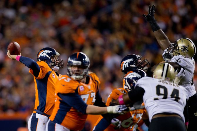 Quarterback Peyton Manning of the Broncos throws a pass over the outstretched arms of the Saints defense during the second quarter on Sunday.