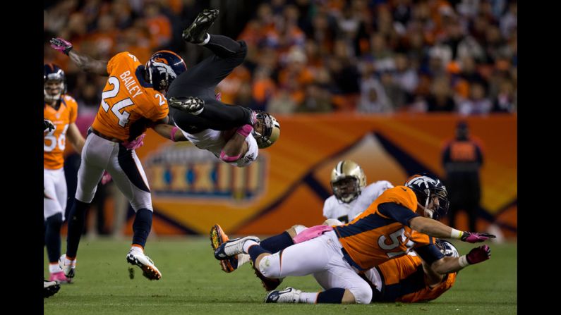 Running back Pierre Thomas of the Saints is upended by cornerback Champ Bailey of the Broncos during the second quarter.