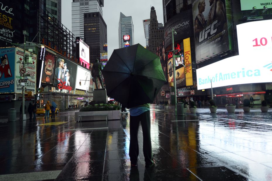 A lone tourist stands in Times Square early Monday as New Yorkers brace against Hurricane Sandy.