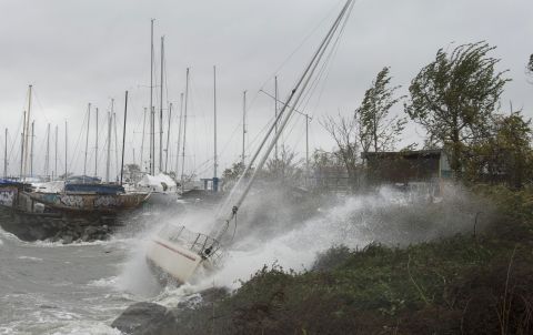 A sailboat smashes on the rocks after breaking free from its mooring on City Island, New York, on Monday.