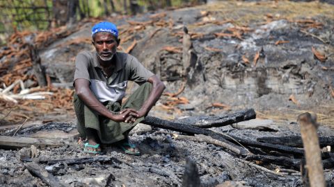 A Muslim Rohingya man sits at his burnt home at a villaged in Minpyar in Rakhine state in October.
