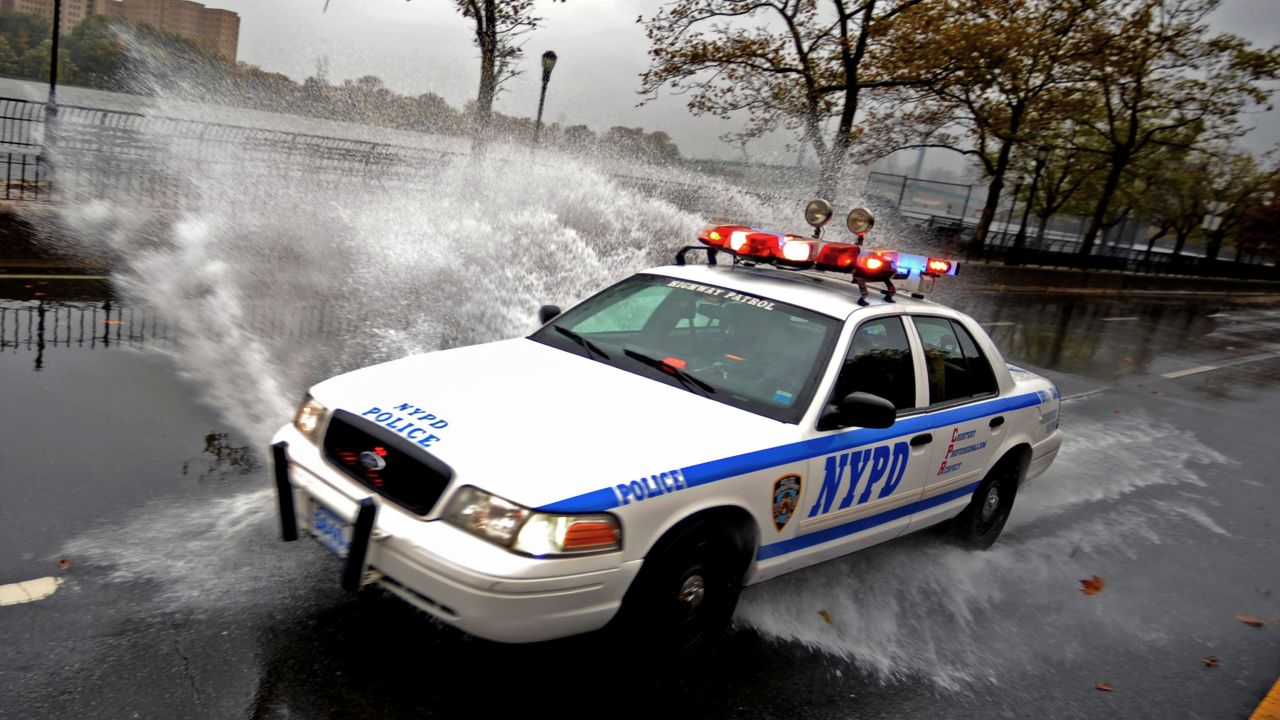 A police vehicle drives through a flooded area in New York on Monday.