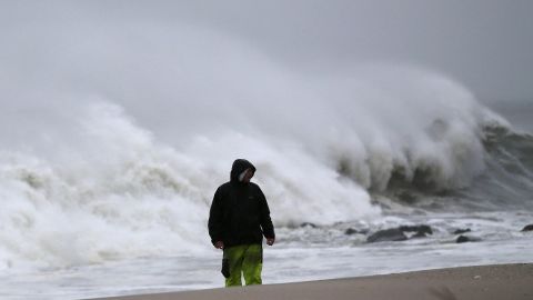 A man stands on the beach as heavy waves pound the shoreline Monday in Cape May, New Jersey.