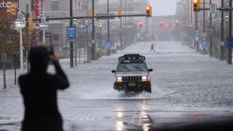 A member of the press takes a photo of a flooded street on Monday in Atlantic City, New Jersey.
