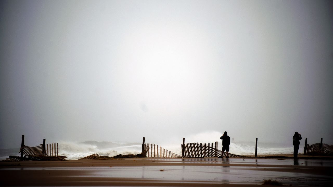 Two people stand near the edge of the boardwalk on Monday in Ocean City, Maryland.