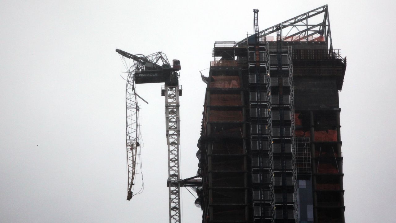 Part of a crane boom is seen hanging off a building under construction in Manhattan on Monday.