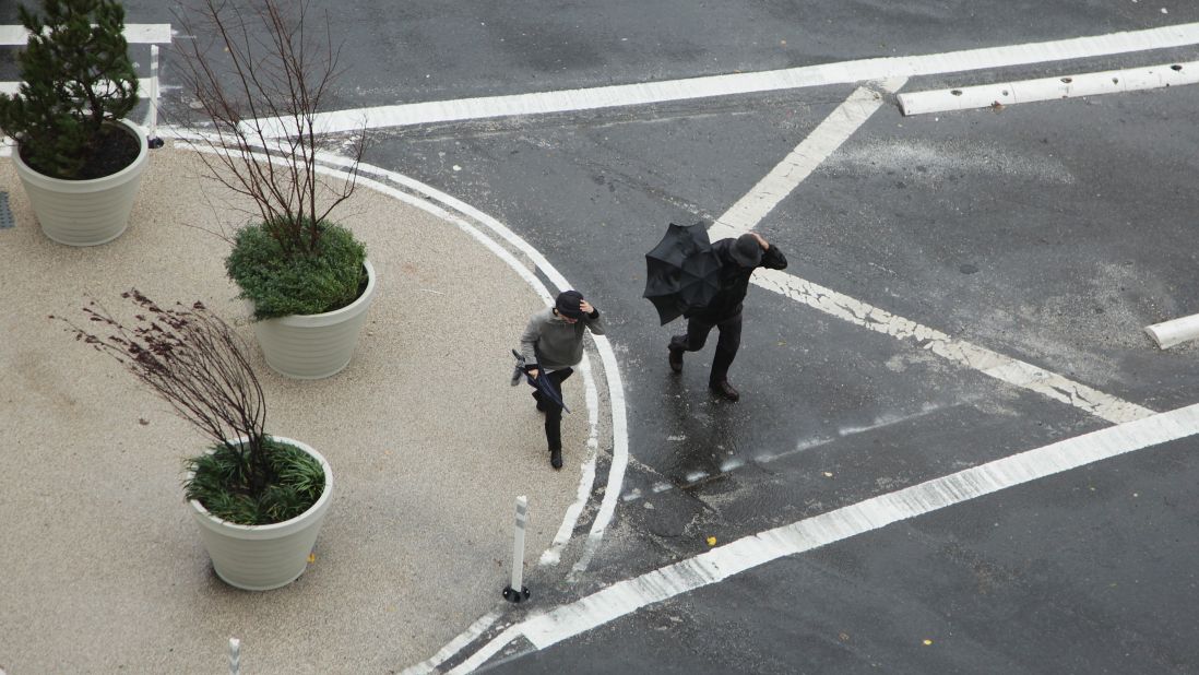 Two people cross the street near the closed Holland Tunnel on Monday as Hurricane Sandy moves up the coast.